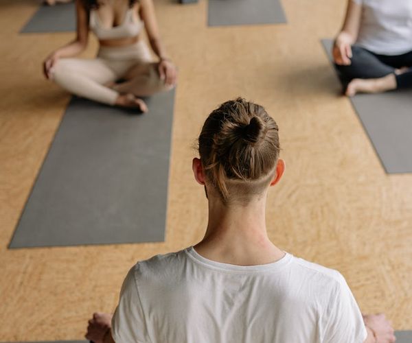 Group of diverse people practicing yoga together on colorful mats.
